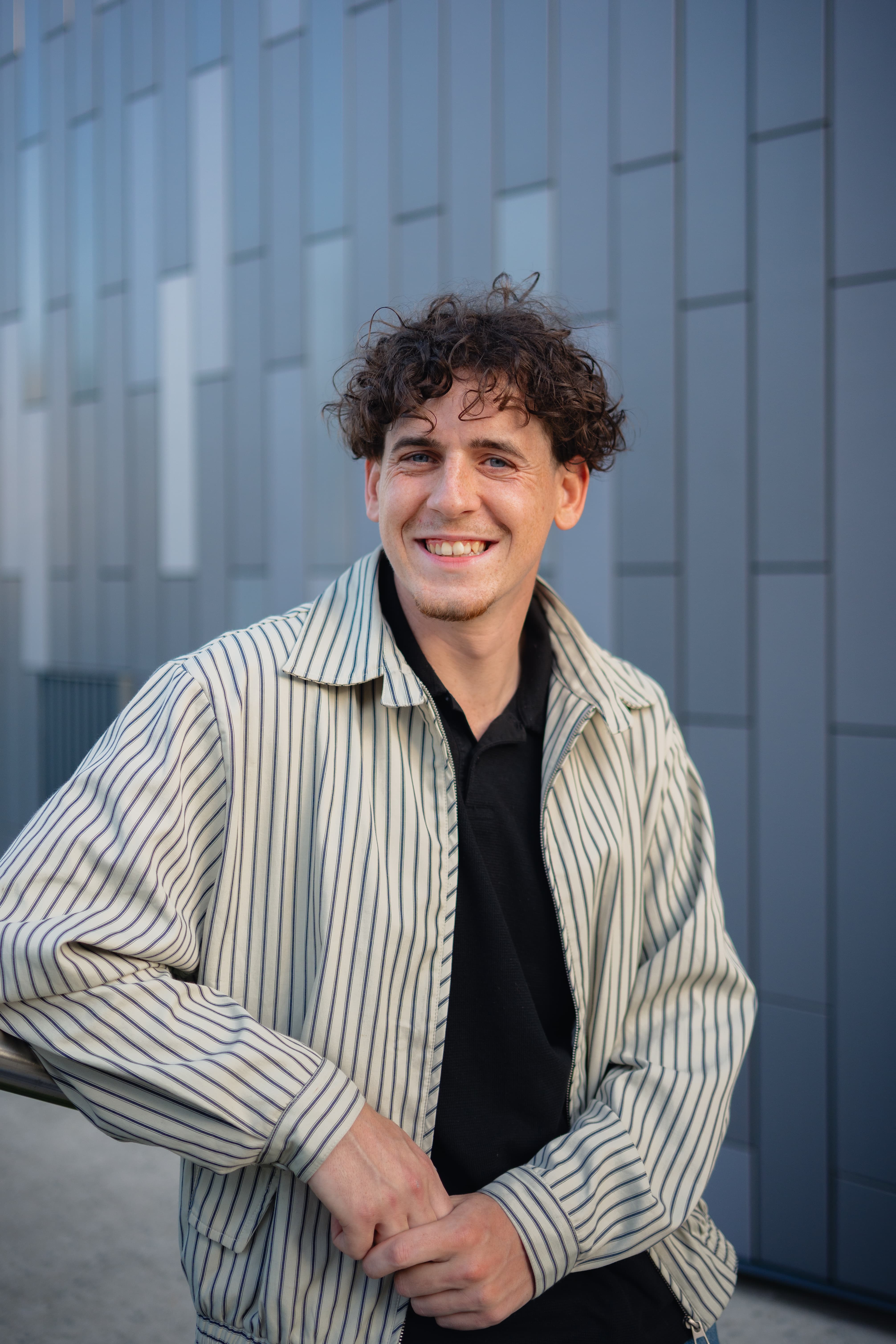 Portrait souriant devant une façade contemporaine, Félix Orain photographe Rennes