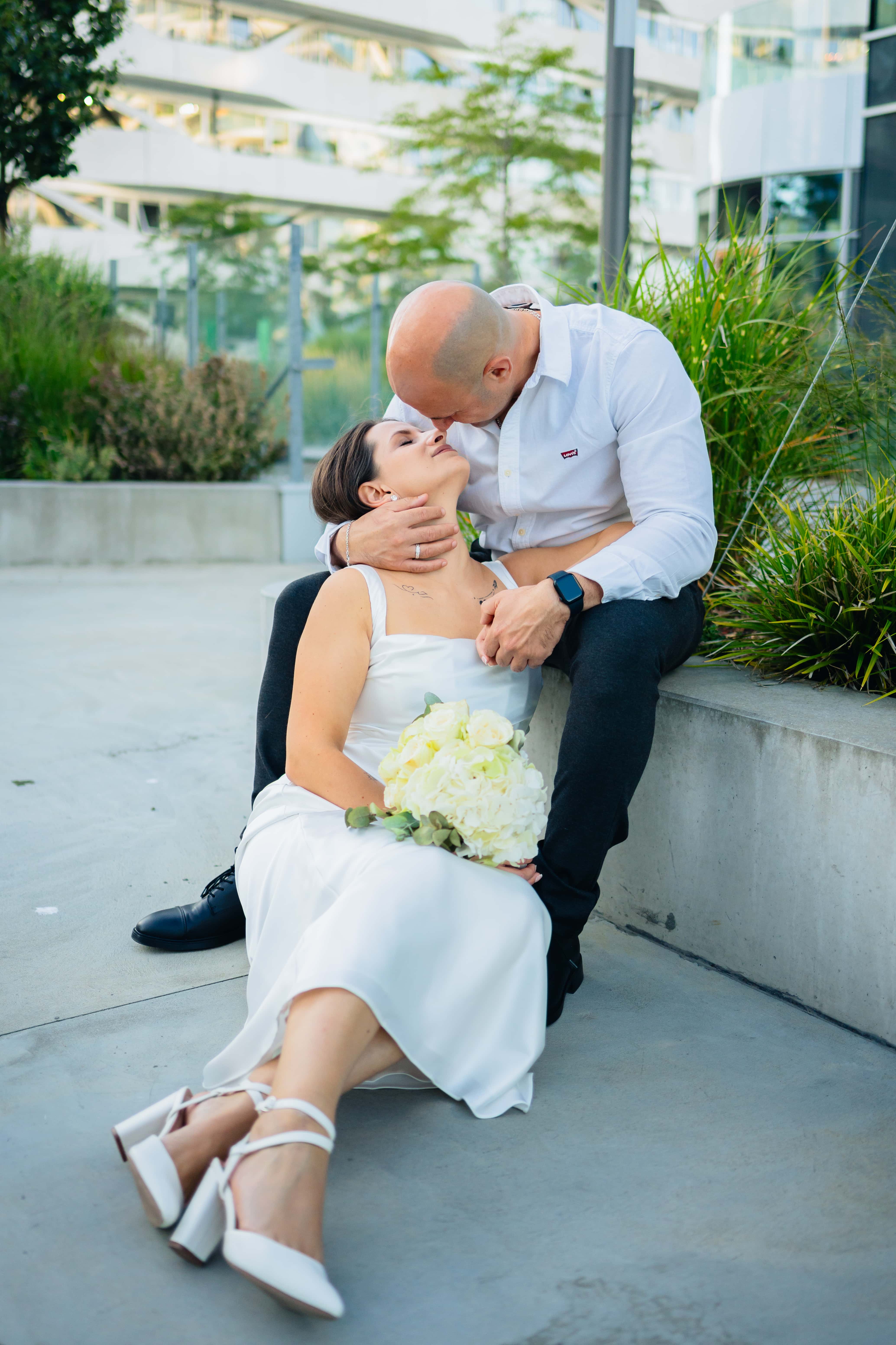 Mariés assis, baiser sur le front, bouquet de roses blanches, Félix Orain photographe mariage Rennes